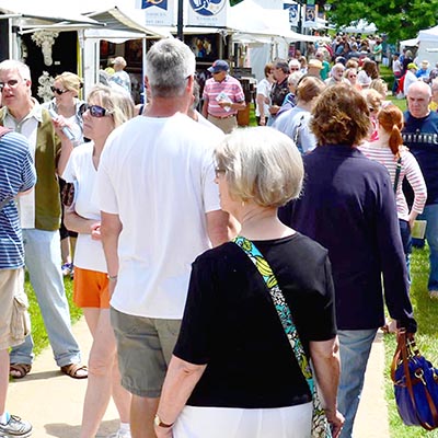 people walking among art fair tents